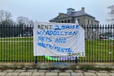 A banner on the fence near the Colonial Building, where for months homeless people have been living in tents. The provincial government has begun removal of some tents, and says more will be removed. SANUDA RANAWAKE • THE TELEGRAM