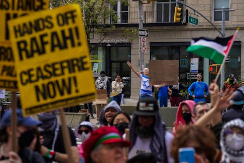 A pro-Israeli counter protestor holds up a sign as demonstrators gather outside of Columbia University to demand a ceasefire and the end of Israeli attacks on Gaza, during the ongoing conflict between Israel and the Palestinian Islamist group Hamas, during a protest in New York, U.S., April 20, 2024.