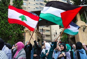 Demonstrators hold Lebanese and Palestinian flags during a protest in solidarity with Gaza at the Lebanese American University (LAU), in Beirut, Lebanon April 30, 2024.