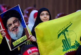 Hezbollah supporters carry a flag and a picture of Hezbollah leader Sayyed Hassan Nasrallah during a rally marking al-Quds Day, (Jerusalem Day) in Beirut's southern suburbs, Lebanon, April 5, 2024.