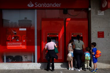 People use an ATM machine at a Santander bank branch in Madrid, Spain, March 22, 2024.
