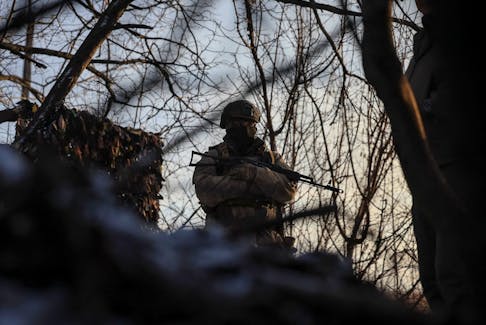 A Ukrainian serviceman stands guard at his position in a trench at a front line on the border with Russia, amid Russia's attack on Ukraine, in Sumy region, Ukraine January 20, 2024.