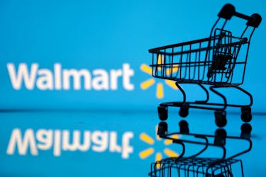 Shopping trolley is seen in front of Walmart logo in this illustration, July 24, 2022.
