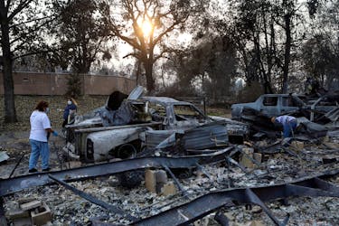 Maria Arevalo, left, and her husband Antonio Silva search for items to salvage in the remains of their burned home, which was destroyed by a wildfire that came through the area in Phoenix, Oregon, U.S. September 22, 2020. 