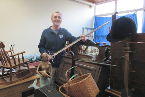 Stephen Sollows, coordinator of the Yarmouth Beacon Church’s Talents and Treasures auction, stands with a sampling of items available for bidding at the April 13 event. CONTIBUTED