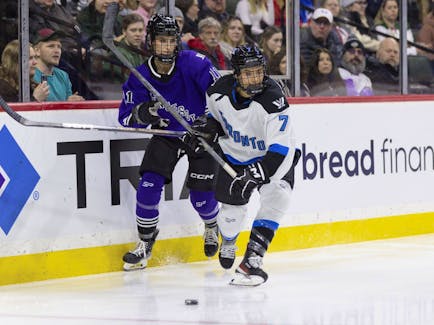 Minnesota forward Sophia Kunin (11) works against Toronto defender Olivia Knowles (7) for the puck during the first period of a PWHL hockey game Wednesday, Jan. 10, 2024, in St. Paul, Minn.
