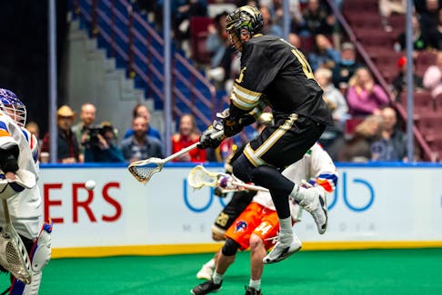 Vancouver Warriors' Keegan Bal leaps in the air before beating Halifax Thunderbirds goalie Warren Hill with one of five goals he scored in his team's 15-13 win at Rogers Arena on Friday night. - National Lacrosse League