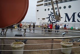 Passengers from the MSC Poesia take photos of the Big Fiddle on Sunday at the Sydney waterfront. CHRIS CONNORS/CAPE BRETON POST