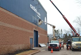 The old sign on the front of Eastlink Centre in Charlottetown is dismantled on April 4. A new digital sign will replace it on the front lawn of the arena and will be visible from either direction. The new digital signage will increase the visibility of the arena and allow events to be projected on a sign that is noticeable from the road. In the past, people had to gaze up to see the list of current and upcoming events. The new signage will  be situated at an angle to allow people coming from either direction to see it. It will cost the city $150,000 and has already been budgeted for the facility. Dave Stewart • The Guardian