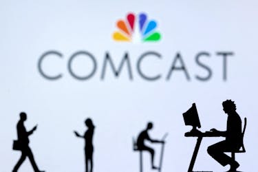 Small toy figures with laptops and smartphones are seen in front of displayed Comcast logo, in this illustration taken December 5, 2021.