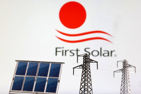 Miniatures of solar panel and electric pole are seen in front of First Solar logo in this illustration taken January 17, 2023.