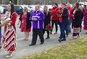 Students, staff and community members marched from Cape Breton University's multiversity room to a green space in front of the Marvin Harvey Building to hang a red dress, lay flowers and offer tobacco in honour of missing and murdered Indigenous women, girls and two-spirit people. Mitchell Ferguson/Cape Breton Post
