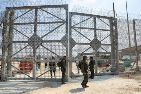 Israeli soldiers stand by a gate in the fence of Erez Crossing, amid the ongoing conflict in Gaza between Israel and the Palestinian Islamist group Hamas, in southern Israel, May 1, 2024.
