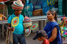 A vendor sells bamboo fans and hats outside Alipore Zoological Garden on a hot summer day in Kolkata, India, May 1, 2024.