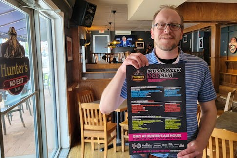 Jamie Juniper, Hunter’s Ale House general manager, holds a poster for music at the bar during ECMA awards week. Hunter’s and three other bars will stay open until 4 a.m. on May 2-4. - Logan MacLean