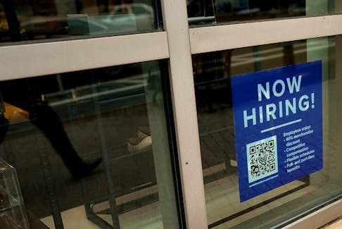 An employee hiring sign with a QR code is seen in a window of a business in Arlington, Virginia, U.S., April 7, 2023.