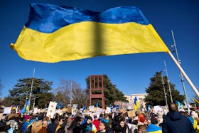 A Ukrainian flag is waved during an anti-war protest, after Russia launched a massive military operation against Ukraine, in front of the United Nations Office in Geneva, Switzerland, February 26, 2022.