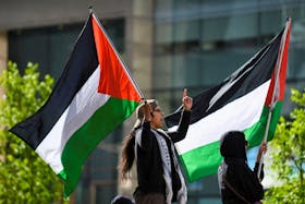 Protesters wave Palestinian flags as students and workers hold a pro-Palestinian rally outside MIT's Stata Center, demanding MIT divest from Israel, among other demands, in Cambridge, Massachusetts, U.S. May 9, 2024.