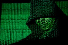A projection of cyber code on a hooded man is pictured in this illustration picture taken on May 13,  2017. Capitalizing on spying tools believed to have been developed by the U.S. National Security Agency, hackers staged a cyber assault with a self-spreading malware that has infected tens of thousands of computers in nearly 100 countries.