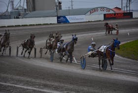 Trainer-driver Mike McGuigan and Islebetu Islebeatu lead the field around the turn for the homestretch in the opening race of a 10-dash harness racing card at Red Shores Racetrack and Casino at the Charlottetown Driving Park. Islebetu Islebeatu, a three-year-old bay filly, won the race over a sloppy track in 2:03.1. Jason Simmonds • The Guardian