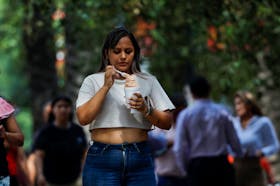A woman eats ice cream to cool off during a heat wave, in Monterrey, Mexico May 9, 2024.