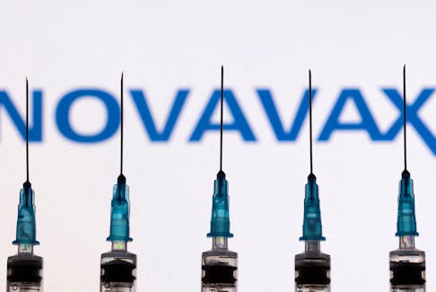 Syringes with needles are seen in front of a displayed Novavax logo in this illustration taken, November 27, 2021.