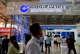 People walk past the China Construction Bank booth at the 2021 China International Fair for Trade in Services (CIFTIS) in Beijing, China September 3, 2021.