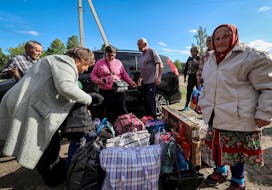 Residents from Vovchansk and nearby villages wait for buses amid an evacuation to Kharkiv due to Russian shelling, amid Russia's attack on Ukraine, at an undisclosed location near the town of Vovchansk in Kharkiv region, Ukraine May 10, 2024.