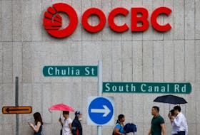 People pass an OCBC Bank signage in Singapore July 11, 2023.