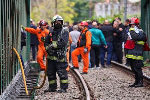 A fire fighters works on the site of a train collision in Buenos Aires, Argentina, May 10, 2024.