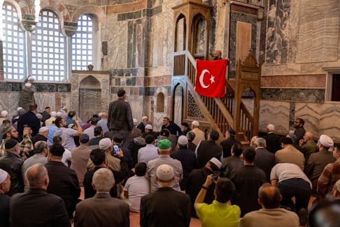 A worshipper holds Turkey's national flag during an afternoon prayer at Chora Museum or Kariye Mosque, one of the city's most celebrated Byzantine churches which was reconverted into a mosque in 2020 and re-opened its doors to visitors and worshippers after a four year-long restoration process, in Istanbul, Turkey, May 6, 2024.