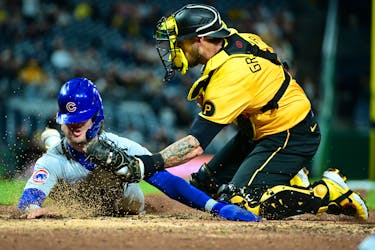 May 10, 2024; Pittsburgh, Pennsylvania, USA; Chicago Cubs second baseman Nico Hoerner (2) is tagged by Pittsburgh Pirates catcher Yasmani Grandal (6) but would score on an error by Grandal in the fifth inning at PNC Park. Mandatory Credit: David Dermer-USA TODAY Sports