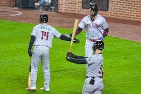 May 10, 2024; Baltimore, Maryland, USA; Arizona Diamondbacks outfielder Lourdes Gurriel Jr. (12) greeted by catcher Gabriel Moreno (14) after scoring in the seventh inning against the Baltimore Orioles at Oriole Park at Camden Yards. Mandatory Credit: Mitch Stringer-USA TODAY Sports