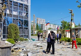 People gather outside a restaurant building hit by recent shelling, which local Russian-installed authorities called a Ukrainian military strike, in the course of Russia-Ukraine conflict in Donetsk, Russian-controlled Ukraine, May 11, 2024.