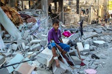 A wounded Palestinian sits on debris at the site of an Israeli strike on a house, amid the ongoing conflict between Israel and the Palestinian Islamist group Hamas, in Rafah, in the southern Gaza Strip May 9, 2024.