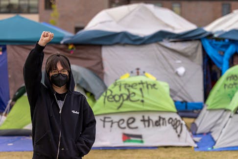 Student protest organizer, Steph W., who wished to be identified by her first name and last initial, raises her right fist as she poses for a portrait at an encampment in support of Palestinians in Gaza, amid the ongoing conflict between Israel and the Palestinian Islamist group Hamas, at the Auraria Campus in Denver, Colorado, U.S., May 10, 2024. 