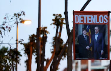 An election campaign poster stating that it was generated using artificial intelligence and showing Exiled Catalan separatist leader Carles Puigdemont, candidate of Junts Per Catalunya (Together for Catalonia) party shaking hands with Spain's Prime Minister Pedro Sanchez, reads "Stop Them", is pictured ahead of the upcoming Spain's Catalonia region election, in Barcelona, Spain May 10, 2024.