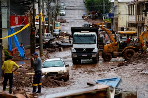 People help to clean houses partially destroyed after floods in Mucum, Rio Grande do Sul state, Brazil May 11, 2024.