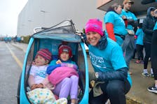 Rachael Germani unzipped the rain cover protecting daughters Raya, 2, and Wylie, 5, from the wet weather Sunday as they attended the Teal to Heal Mother’s Day Run in Membertou. Hundreds attended the annual walk-and-run fundraiser in support of ovarian cancer. The event held at the Membertou Sport and Wellness Centre also featured a wellness expo and live entertainment. Since it was launched in 2022 by Dena Edwards Wadden, who was diagnosed with ovarian cancer at age 33, Teal to Heal has raised more than $200,000 for the Teal at Home Fund offered through the Cape Breton Regional Hospital Foundation and is recognized as the largest fundraiser and awareness campaign for for gynecological cancer in Canada. CHRIS CONNORS/CAPE BRETON POST