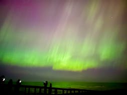 Visitors to Brackley Beach in Prince Edward Island National Park view the aurora borealis through cameras on their devices just before midnight on May 10. While the northern lights can be visible in the night sky close to the North Pole any night between August and May, it is rare for the colours to appear so vividly in P.E.I. Thinh Nguyen • The Guardian