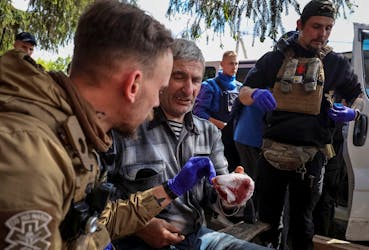 Military paramedics treat a wounded local resident during an evacuation to Kharkiv due to Russian shelling, amid Russia's attack on Ukraine, in the town of Vovchansk in Kharkiv region, Ukraine May 12, 2024.