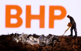 A small toy figure and mineral imitation are seen in front of the BHP logo in this illustration taken November 19, 2021.