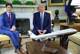 U.S. President Donald Trump and Canada's Prime Minister Justin Trudeau sit behind a scale model of Air Force One as they meet in the Oval Office of the White House in Washington, U.S., June 20, 2019. REUTERS/Jonathan Ernst