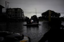 Police officers patrol on a jet ski in a flooded area to prevent theft in the downtown of Porto Alegre, Brazil, May 12, 2024.