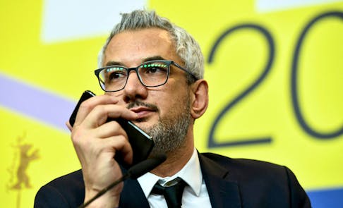 Director Mohammad Rasoulof, winner of the Golden Bear for Best Film for "There Is No Evil", speaks through a video call as producer Farzad Pak holds a cellphone, during a news conference after the award ceremony of the 70th Berlinale International Film Festival in Berlin, Germany February 29, 2020.