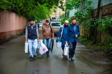 Polling officials walk towards their designated vehicle after collecting election materials at a distribution centre, ahead of the fourth phase of the general elections, in Srinagar May 12, 2024.