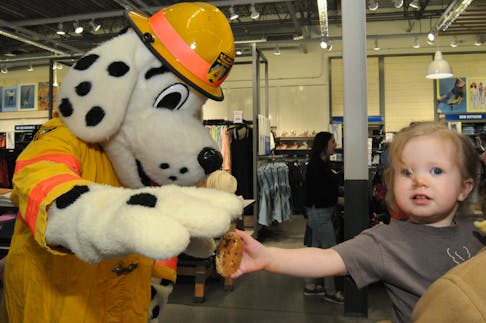 Sparky gets a cookie
St. John’s Regional Fire Department mascot Sparky is excited to be offered a cookie by two-year-old Clara Templeton, daughter of Christina Templeton of St. John’s, at the Old Navy Super Safety Event on Saturday, May 11, 2024 at the Avalon Mall. The day is aimed at promoting child safety in communities across the country by inspiring families to be more safety conscious, and to understand the risks their kids might face and know the steps that can be taken to avoid the risks. — Photo by Joe Gibbons/The Telegram