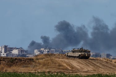 An Israeli tank holds a position as smoke rises in Gaza, near the Israel-Gaza border, amid the ongoing conflict between Israel and the Palestinian Islamist group Hamas, in Israel, May 13, 2024.