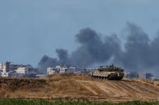 An Israeli tank holds a position as smoke rises in Gaza, near the Israel-Gaza border, amid the ongoing conflict between Israel and the Palestinian Islamist group Hamas, in Israel, May 13, 2024.