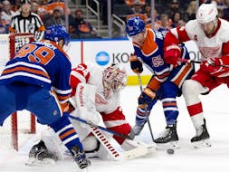 Edmonton Oilers Sam Gagner (89) and Dylan Holloway (55) battle for the puck against Detroit Red Wings goalie Alex Lyon (34) at Rogers Place in Edmonton on Tuesday, Feb. 13, 2024. The Oilers won 8-4.